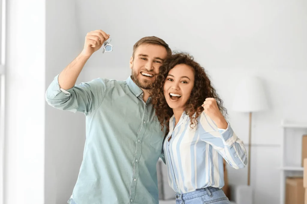 An image of a happy couple holding a house key