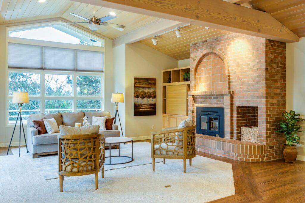 A cozy living room featuring a soft carpet and a warm fireplace, creating a welcoming and comfortable atmosphere. Ideal for a first time buyer, offering a perfect blend of comfort and style in their new lease-to-own home.