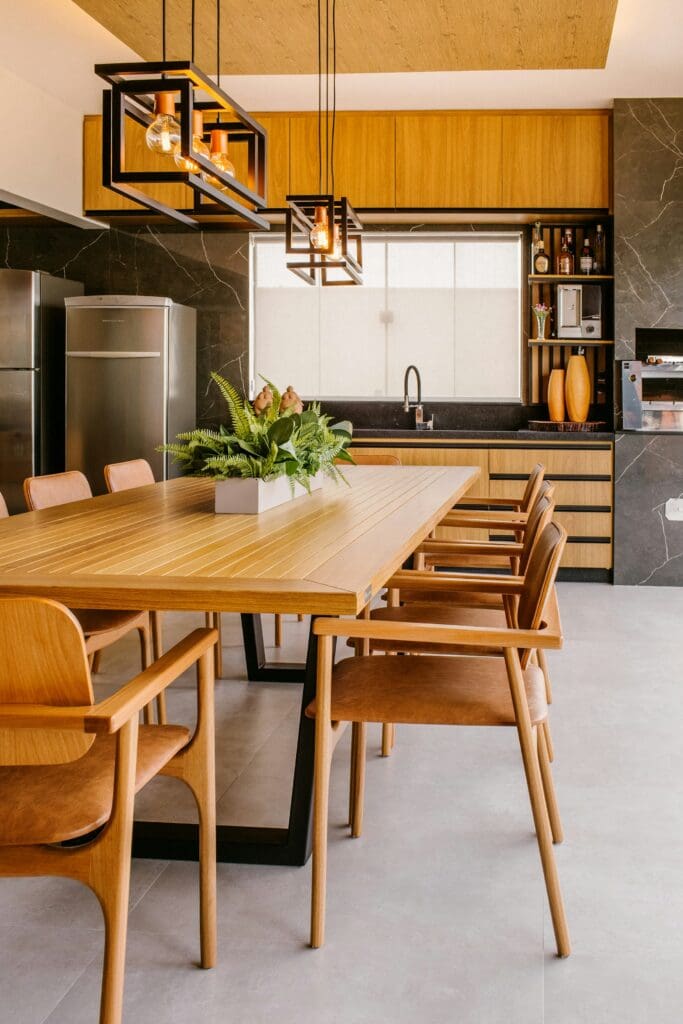 A beautiful dining area featuring a matching brown kitchen table and chairs, illuminated by elegant overhead lighting. An inviting space in a lease to own home in Raleigh, offering a perfect setting for family meals and gatherings.