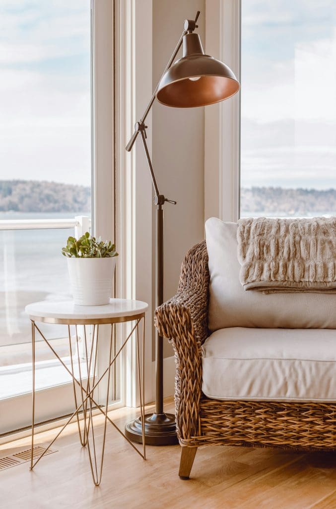 A stylish sofa chair placed in the cozy corner of a room, accented with a decorative pillow and a small side table, showcasing the warmth of turning a house into a lease-to-own home.