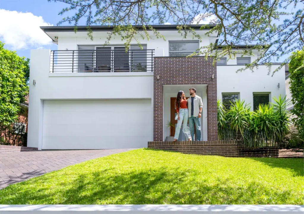 Couple standing in front of their new lease to own Greensboro house.